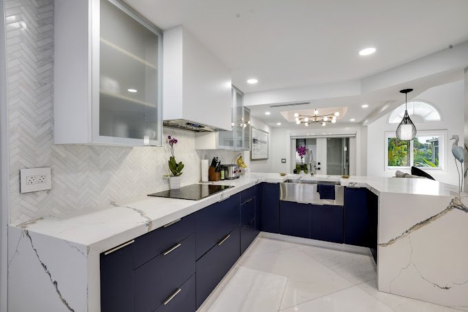 a kitchen with blue cabinets and white counter tops